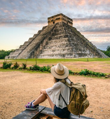 girl sitting looking at chichen itza 