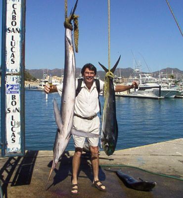 man posing with its catch, a marin and dorado in the bay of cabo san lucas, mexico