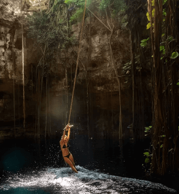 girl swinging in a cenote in cancun