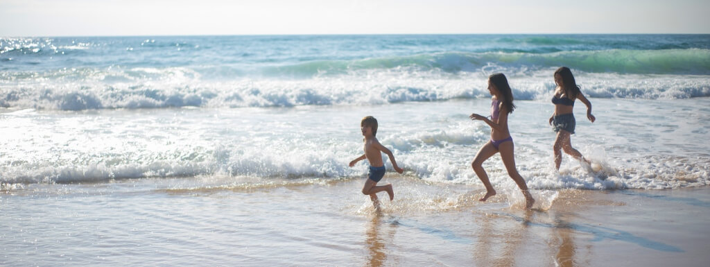 niños corriendo en la playa de un resort todo incluido